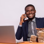 african business man with a lot of money making a phone call